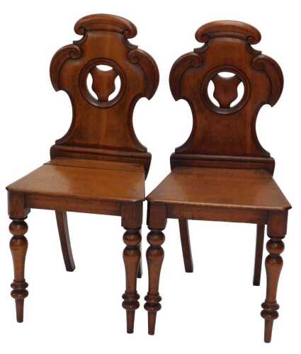 A pair of late 19thC oak hall chairs, with shaped floral backs and turned front legs, 85cm high....
