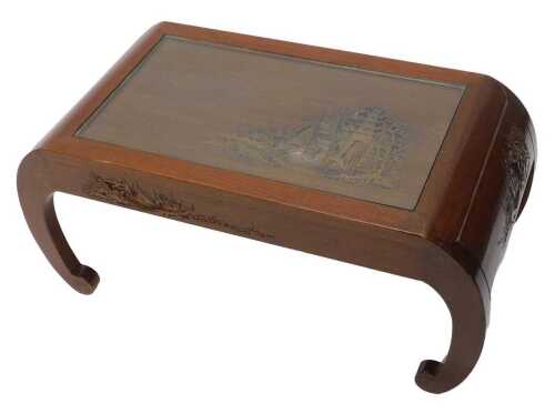 A 20thC carved Japanese coffee table, the glazed top above a heavily carved scene of figures and...