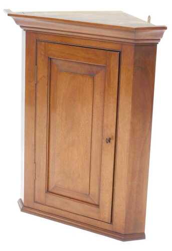 A George III style mahogany corner cupboard, of small proportion, with panel door and plain...