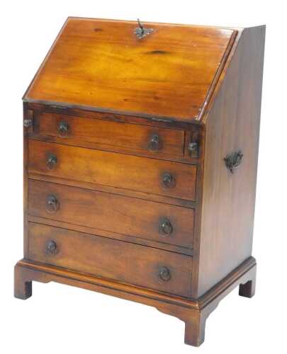 A late 20thC hardwood bureau, the fall revealing a fitted interior above four drawers, on...