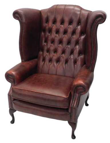 An 18thC style wing armchair, of large proportion, with button back, removable cushion,...