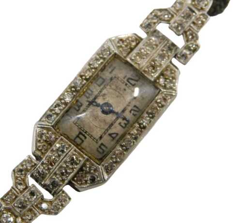 An Art Deco lady's cocktail watch, the case set with tiny diamonds, the dial with blue hands and...