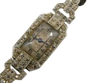 An Art Deco lady's cocktail watch, the case set with tiny diamonds, the dial with blue hands and...