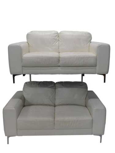 A two piece lounge suite, comprising two two seater settees in white stitched Italian leather,...