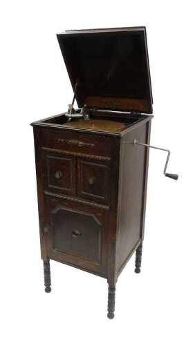 A mid 20thC Alba freestanding gramophone, in oak case, with cupboards to the front, on turned...