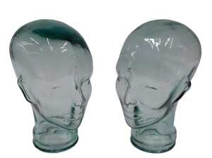 A pressed moulded glass head, 26cm high, and another similar. (2)