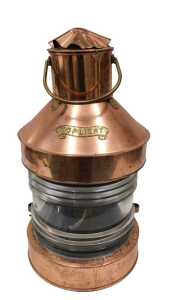 An early 20thC Toplight copper and brass ship's lantern, with glazed front, swing handle, later...