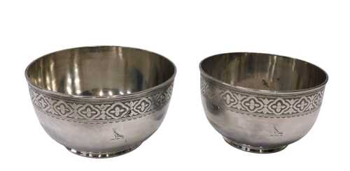 A graduated pair of silver plated bowls, with upper floral and geometric banding, etched with...