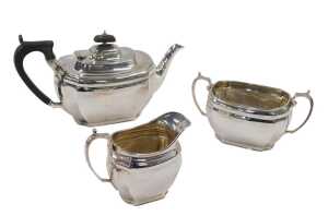 A George V three piece silver tea service, comprising teapot of cape form with thumb mould...