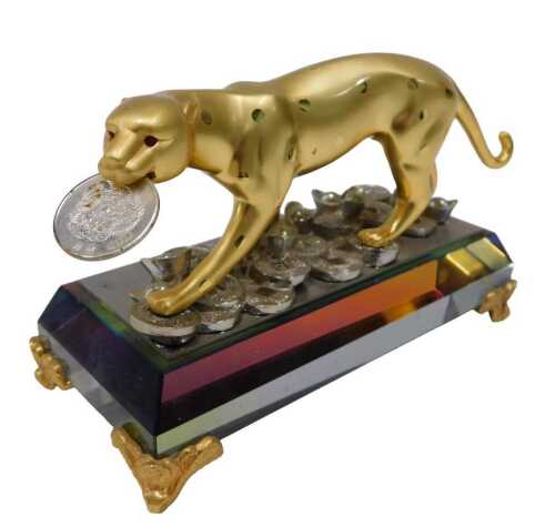 A figure of a Lucky Leopard, with coin to mouth, opalescent glass base terminating in scroll...