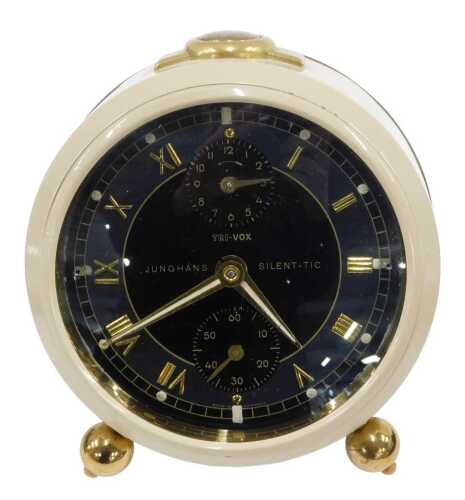 A Junghans Tri-vox alarm clock, white case with brass coloured buttons, on orb feet, with 8cm...