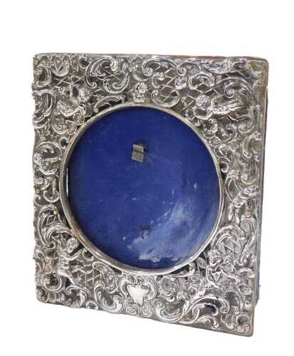 An Edward VII silver photograph frame, of square form, heavily repousee decorated with scrolls...