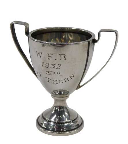 A George V silver miniature trophy, with angular handles, egg shaped body, inverted circular...