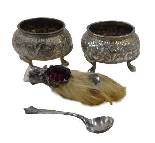 A pair of 20thC open salts, each of circular form, repousse decorated with scrolls, on triple...