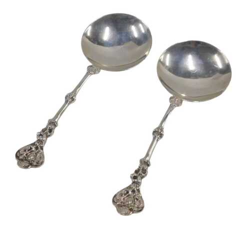 A pair of George V silver serving spoons, each with turned repousse decorated handles, plain...