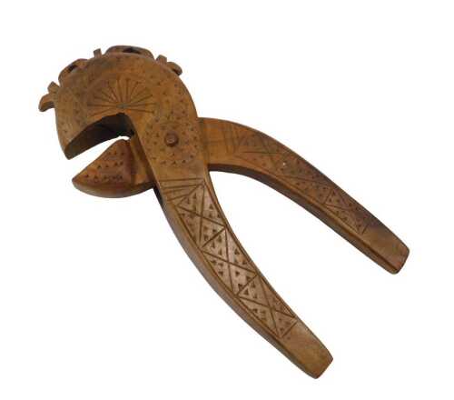 An early 20thC Scandinavian folk art nutcracker, heavily carved with geometric pattern, 18cm high.