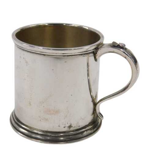 A George VI silver mug, of plain cylindrical form, with thumb mould S scroll handle, on circular...