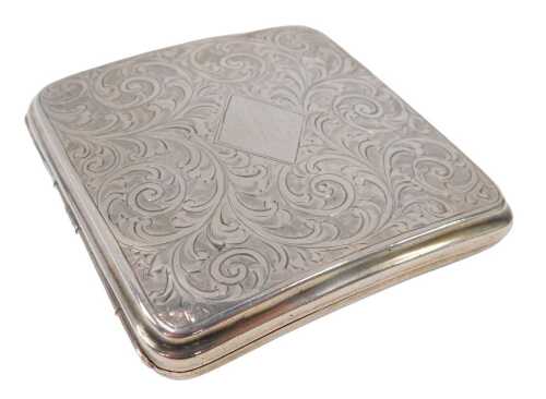 A George V silver cigarette case, of curved form, chased with scrolls, with a vacant diamond...