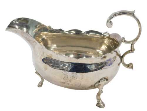 A George III silver sauceboat, with flying angular handle, flared rim and triple hoof feet, by...