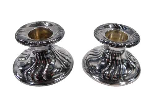 A pair of 20thC silver dwarf candlesticks, of circular form, marks rubbed. (2, AF)