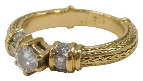 A diamond dress ring, the central round brilliant cut diamond in six claw setting, with three...