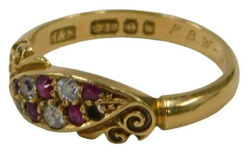 An 18ct gold ruby and diamond crossover ring, the central marcasite panel set with five diamonds...