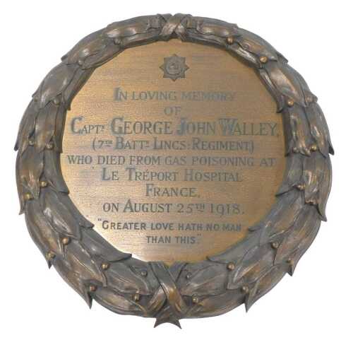 A bronze and brass memorial plaque, in the form of a laurel wreath, commemorating Captain George...