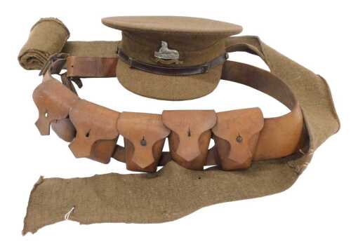 A British Army service cap, stiff top and peak, oil skin liner, and Lincolnshire Regiment badge...
