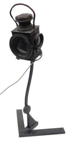A retro table lamp, formed with miniature railway lantern top, on hand forged articulated metal...