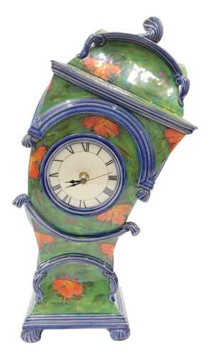 A Ross Emerson design leaning clock, the 9cm diameter Roman numeric dial in a pottery case,...