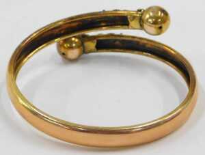 An early 20thC torque bangle, the two splayed bracelet, with raised ball and scroll design, and... - 2