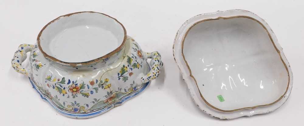 An 18thC French Faience lidded tureen, of shaped oval form, profusely ...