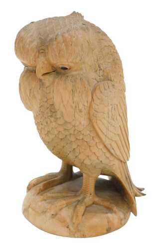 A 20thC hardwood figure of a standing owl, heavily carved, probably Indonesian, 27cm high.
