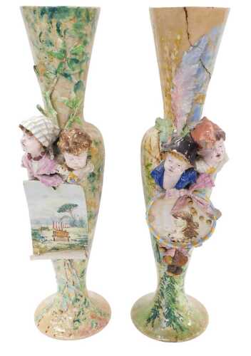 A pair of floor standing Continental porcelain vases, each raised with figures of children with...