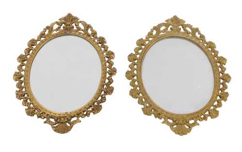 A pair of early 20thC gilt metal mirrors, each of oval form with elaborate pierced scroll...