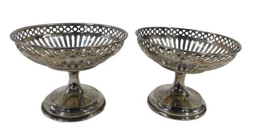 A pair of George V silver footed bowls, each pierced top on an inverted stem and circular foot,...