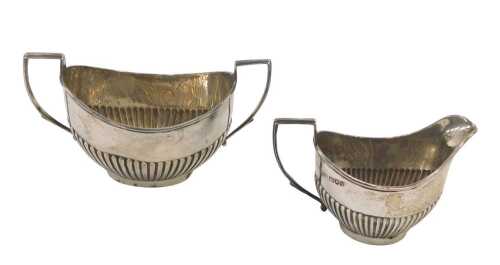 An Edward VII silver bachelors milk jug and two handled sugar bowl, each of weighted classical...