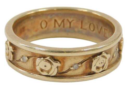 A 9ct gold wedding band, with rose decoration and inset with tiny diamonds, with internal...