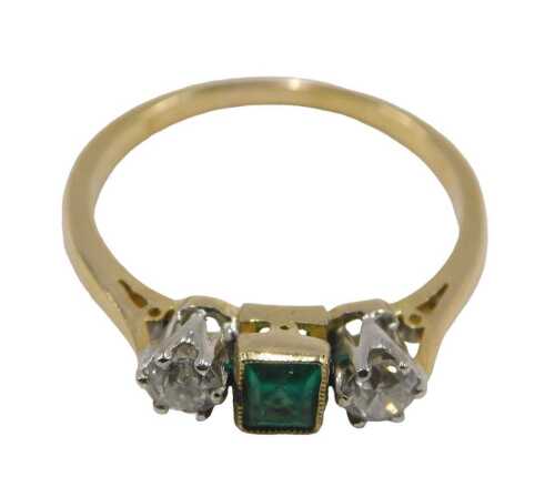 An emerald and diamond dress ring, set with square cut emerald, in a rub over setting, flanked...