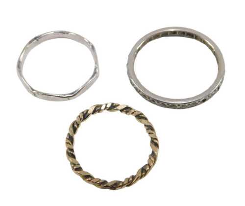 Three dress rings, comprising a yellow metal coloured twist ring, unmarked, ring size G, a CZ...