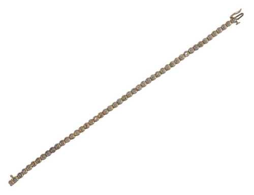 A 9ct diamond line bracelet, each link formed as a circle, in illusion white gold claw setting,...