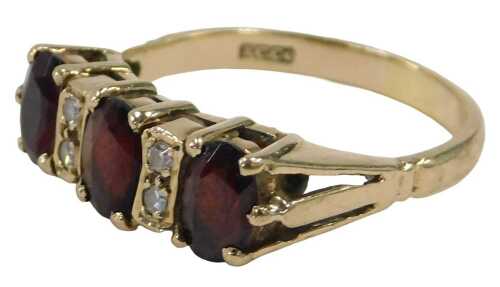 A 9ct gold garnet and CZ dress ring, set with three oval garnets, each claw set, and four CZs,...