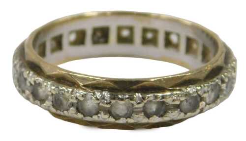 An eternity ring, in white and yellow gold, set with claw set czs, yellow metal stamped 9ct,...