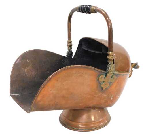 An early 20thC copper coal helmet, with swing and fixed handles, and ebonised turned grips, on a...