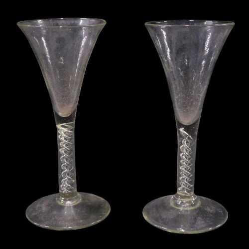 A near matching pair of 18thC ale glasses, each with trumpet bowls, double air twist stems, and...