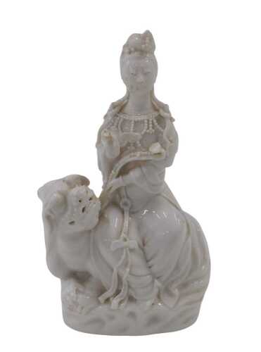 A 20thC Chinese blanc de chine hollow figure of a lady on dragon, unmarked, 18cm high.