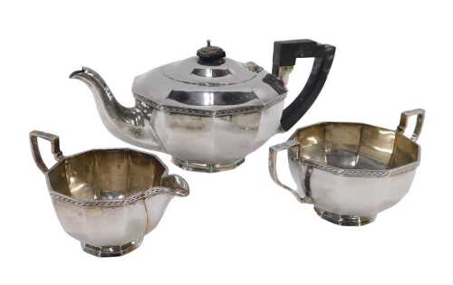 A George VI silver three piece tea service, to include teapot, of compressed shaped form, with...