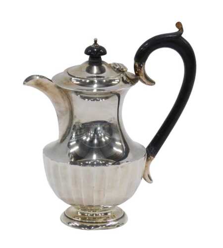 A George V silver coffee pot, with ebonised thumb mould handle and circular knop, the inverted...