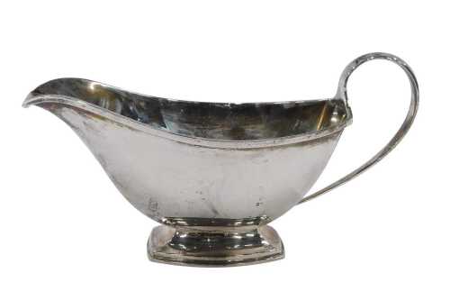 A George VI silver sauceboat, of plain form with plain handle on inverted shaped foot, by John...