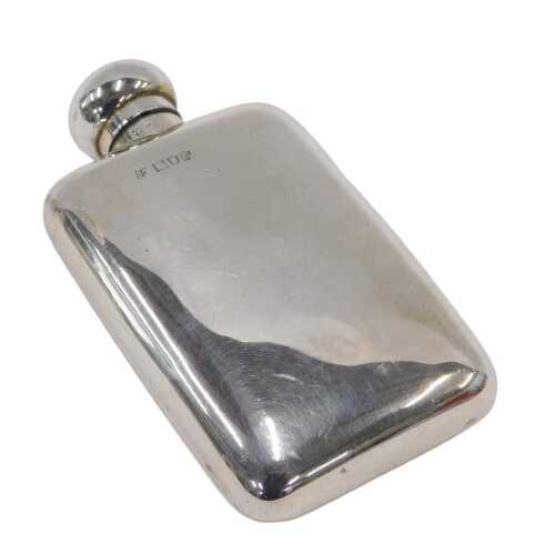An Edward VII silver hip flask, with compressed orb hinged lid, with part cork section, open...